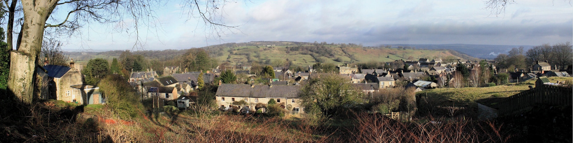 Winster is a well-preserved Derbyshire village west of Matlock. The vantage point of this composite photo is The Flat at the top of the lower branch of East Bank. It's just southwest of the Old Lead Mines near the centre of this 1899 map. Until the Leacroft Road estate was built in the mid 20th century, Winster comprised the three roads shown in the 1899 map. The most important, Main Street, is in the north of the village and runs east/west. South of Main Street the land rises towards the high ground known as Winster Bank. Two roads that lead south from Main Street and towards the Bank are known as West Bank and East Bank. This shot looks north so West Bank is to the left and East Bank is to the right. About half way up the hill, East Bank divides into two with one branch leading southwest and ending up as The Flat – the point from which this photo was taken. The other branch initially leads southeast but soon swings right and continues in a westerly direction until it joins West Bank at the point marked as Winster Bank on the map. The places that I've identified in notes include the tower of St John the Baptist's Church, Birchover Wood, the Dower House, West Bank House, Winster Hall, the Burton Institute and the former Tallow Factory.