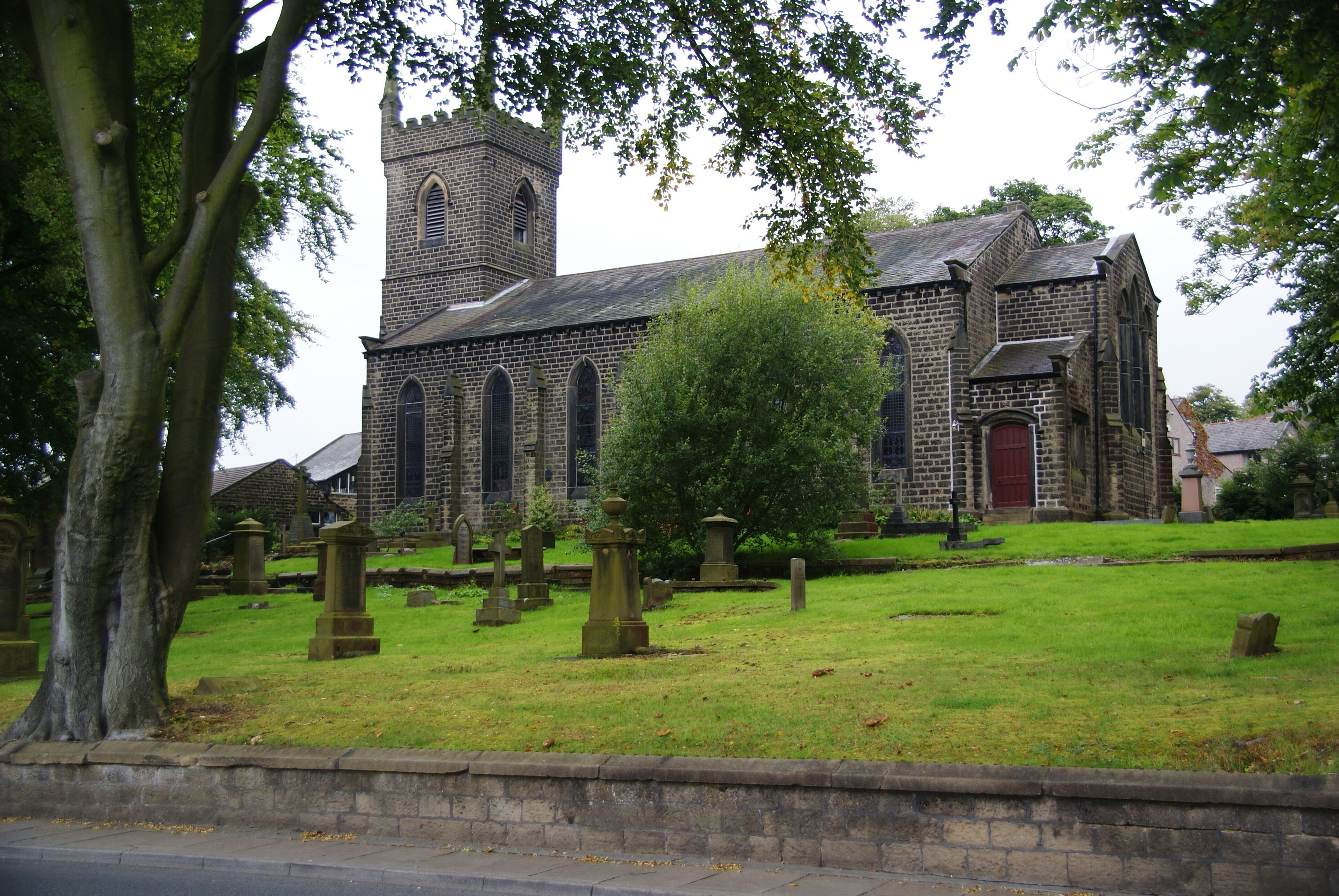 A historic church with a prominent tower and a cemetery in front.