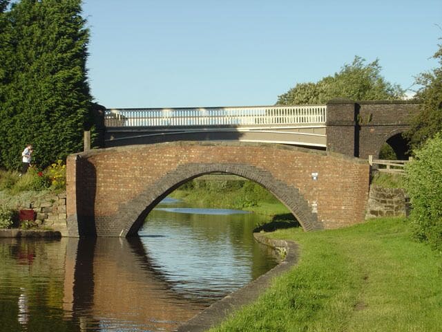 Buckford Bridge The old and the 'new'. The traditional brick canal bridge now only gives pedestrian access to the canal towpath. The new bridge was built to cross the railway which is alongside the canal at this point.