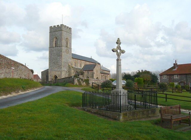 War memorial, High Street, Wighton A cross pierced by a diamond shape, and railed off which seems unusual for a quiet village, sited on a little triangular green.