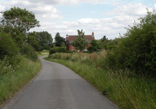 The northwest approach to Farley Green The building is Golden Farm.