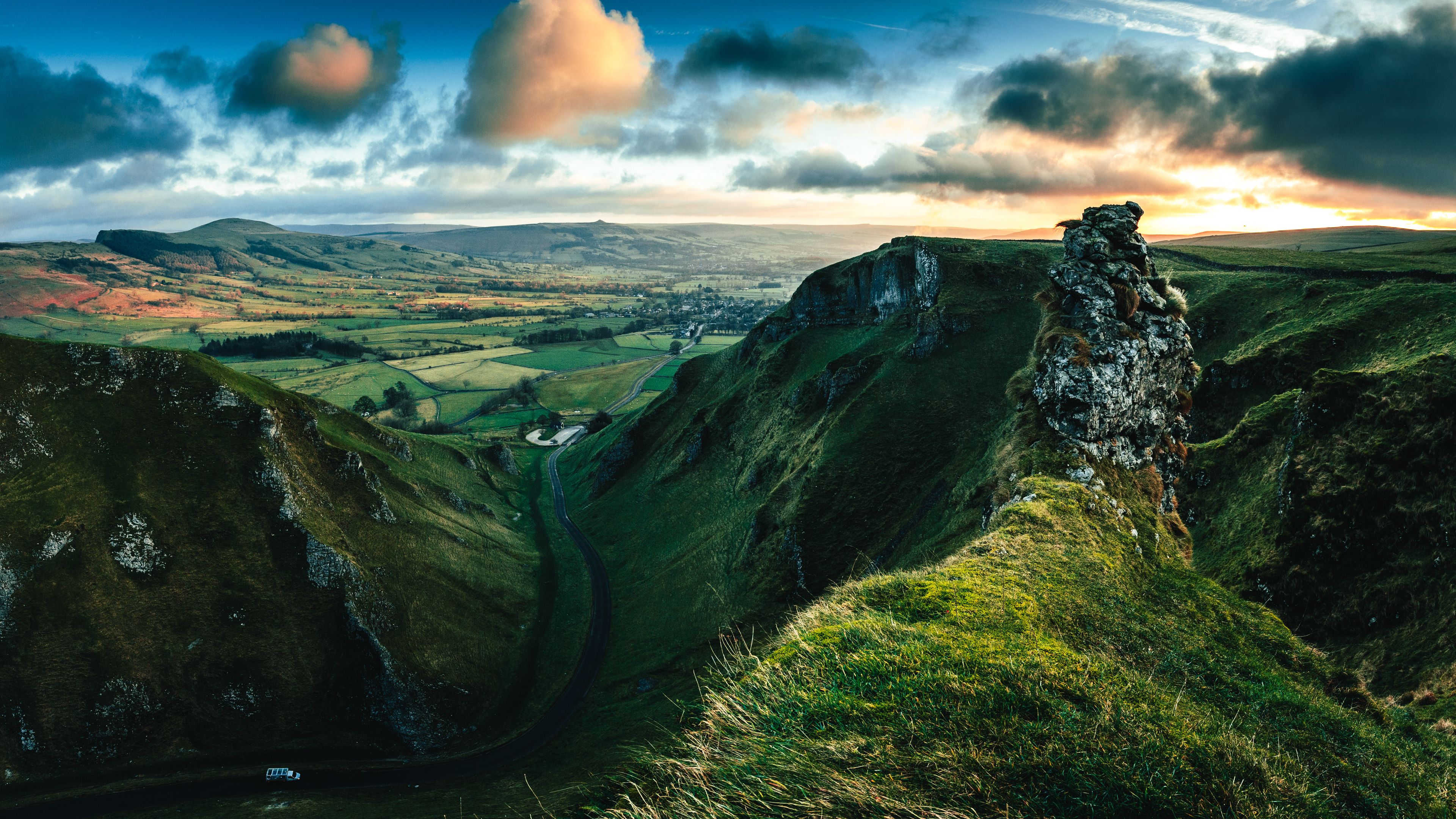 A rugged landscape with a prominent rock formation and a valley below.