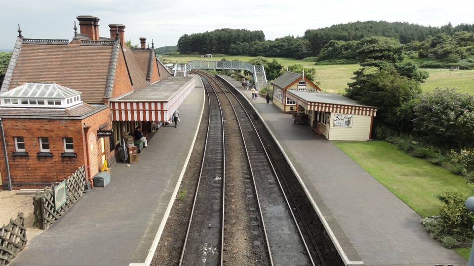 A railway station with tracks, platforms, and buildings.