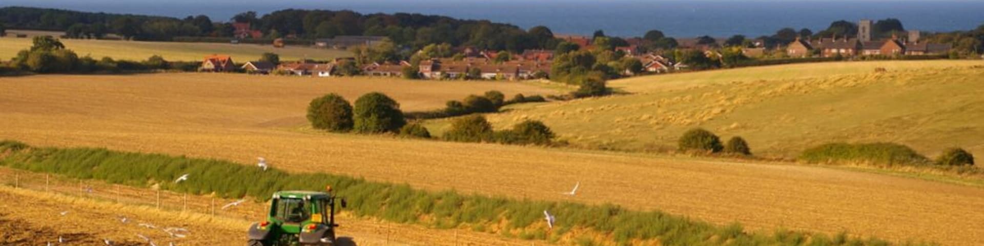 Farmland near Kelling Heath, near to Weybourne, Norfolk, Great Britain. The village of Weybourne can be seen in the distance of this image taken from the North Norfolk Railway.