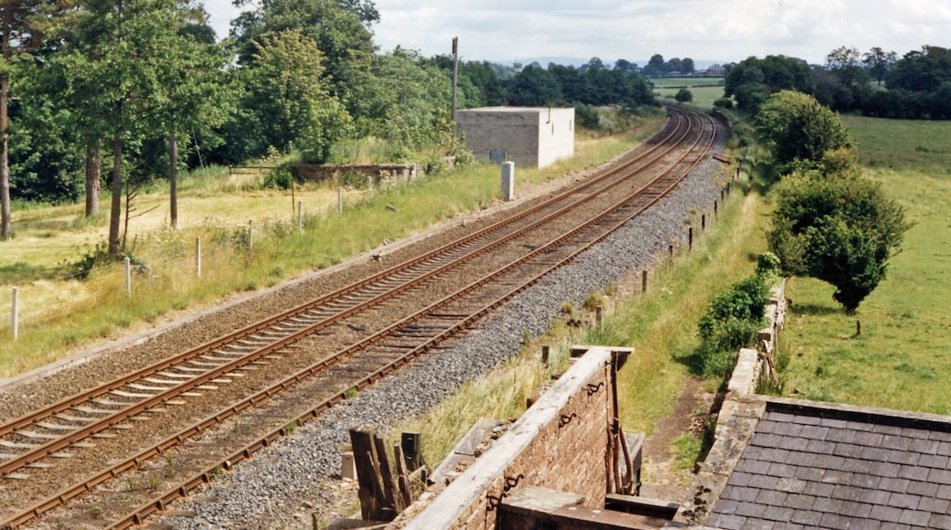 Site of Curthwaite station, 1986. View eastward, towards Carlisle: ex-Maryport & Carlisle Workington - Maryport - Carlisle secondary main line. The station had been closed from 12/6/50 (goods, 6/1/58), but the line remains active.