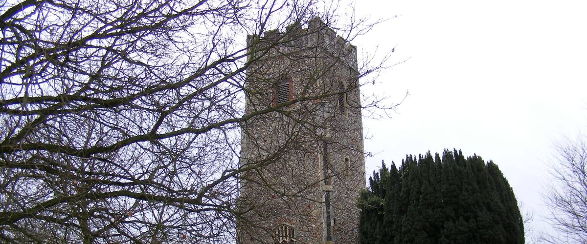 A church with a tall tower and a graveyard.