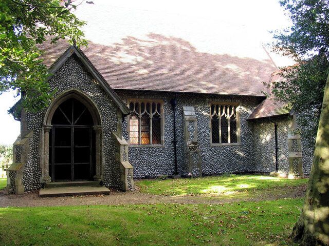 A stone church with a pointed arch entrance and a tiled roof.