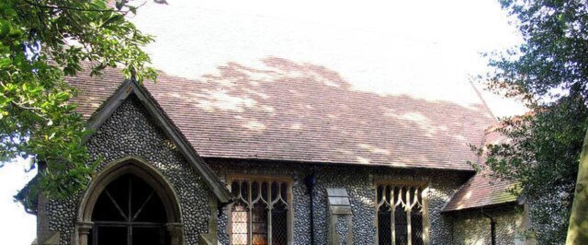 A stone church with a pointed arch entrance and a tiled roof.