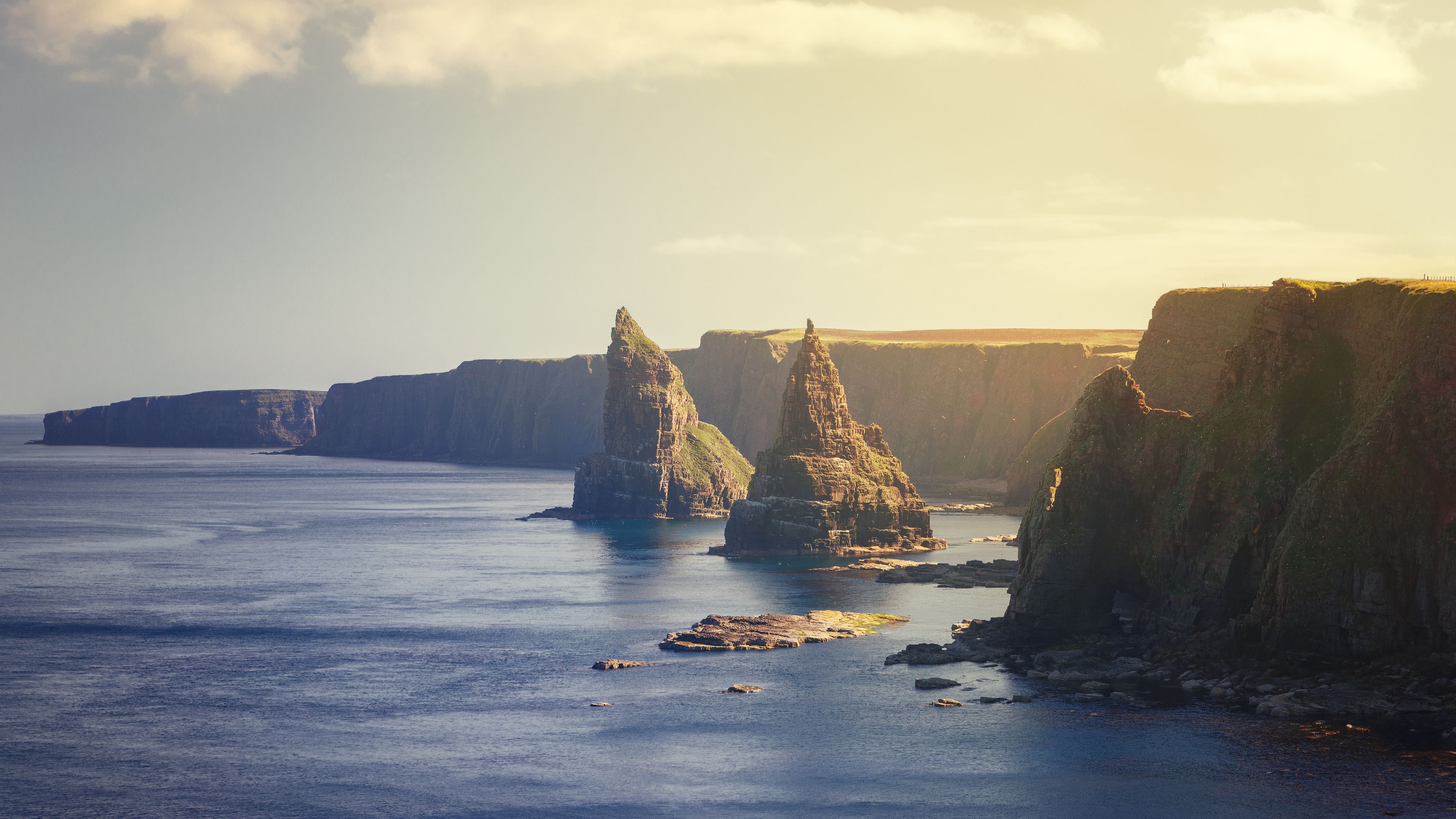 A coastal landscape with prominent rock formations and cliffs.