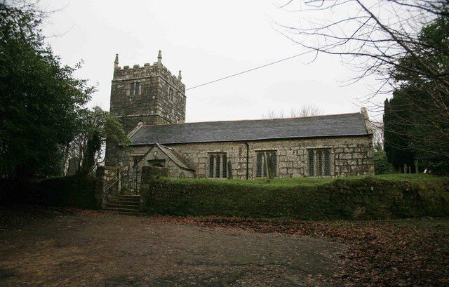 A stone church with a tower and a well-maintained lawn.