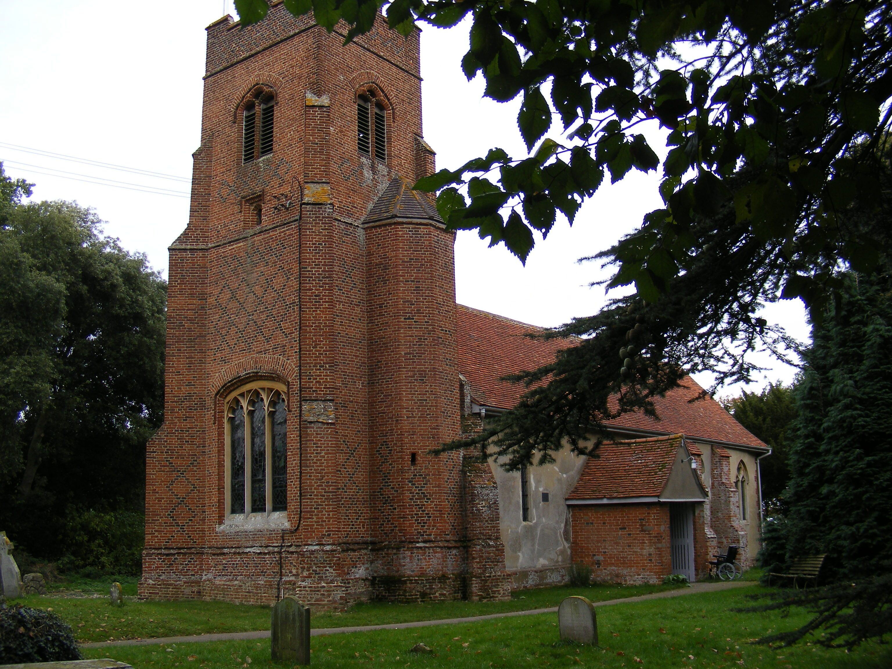 A historic brick church with a tall tower and arched windows.
