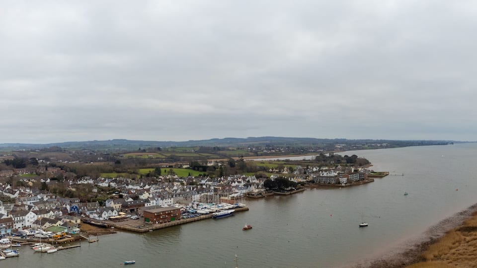 A river flowing through a town with boats docked along the riverbank.