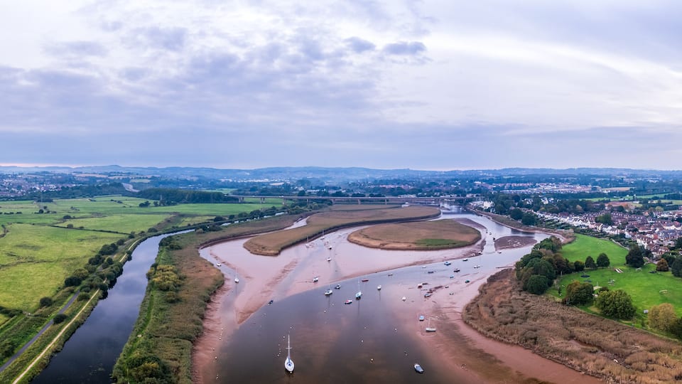 A river meandering through a rural landscape with fields and a small town.