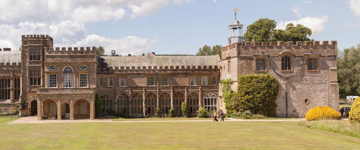 A large, historic castle with multiple towers and arched windows.