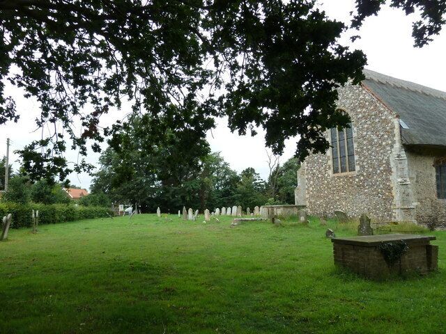 A stone church with a grassy cemetery in the background.