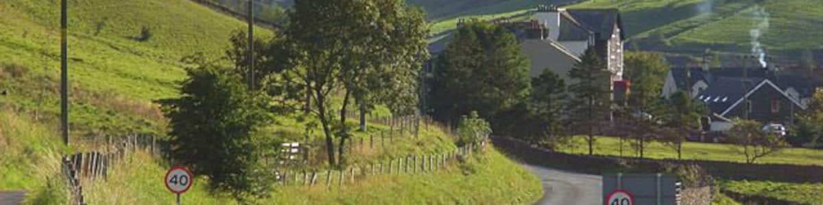 The A685, Tebay The road leaving the main part of the village as it makes its way towards Kendal. The buildings ahead are just above the site of the former railway station. The former Junction Hotel is prominent. The narrow valley is that of the River Lune. It separates the Howgill Fells to the left from the foothills of the Lake District to the right. As well as the road, the M6 and the West Coast Mainline run through this gap in the hills.
