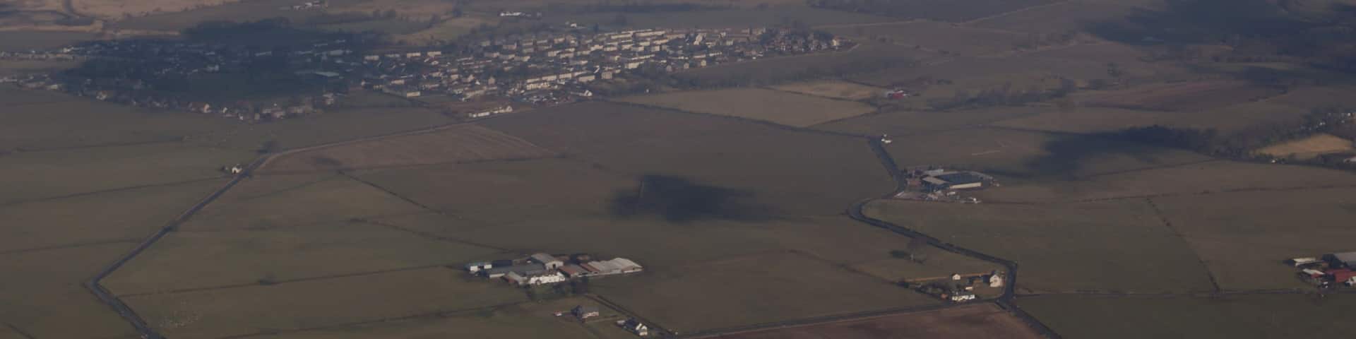 Tarbolton from the air Viewed from a Ryanair flight which has just taken off from Prestwick Airport. The farm in the centre foreground is West Carngillan.