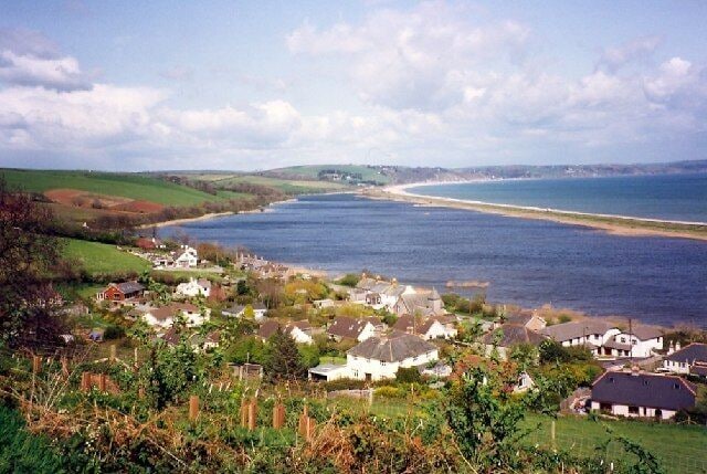 Torcross and Slapton Ley, Stokenham. This is the view from the minor road high up above the village, just before it dives down steeply. The subject NGR is for the church, just to the right of the centre of the picture. Taken in 1992.