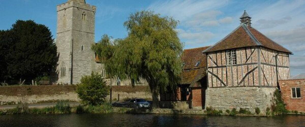 A historic tower, a Tudor-style building, and a river.