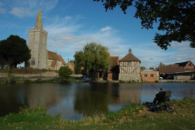 Staunton Church and duck pond A picturesque scene with a man sat fishing in a duck pond in front St James's church and Staunton Court.