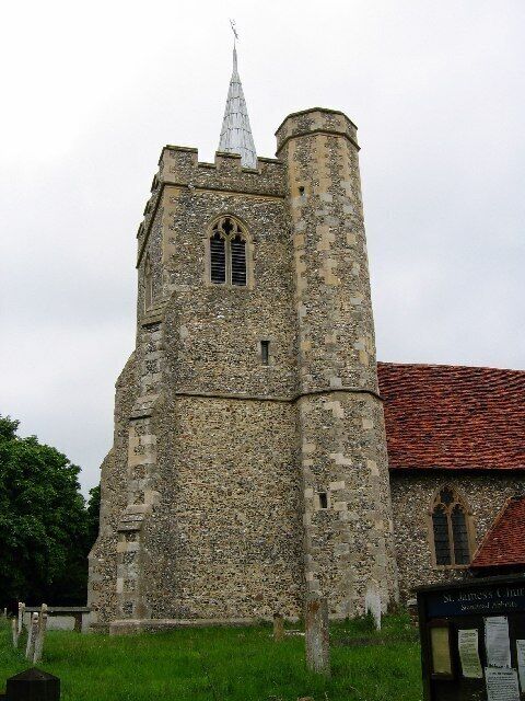 A historic stone church with a tall tower and a pointed spire.