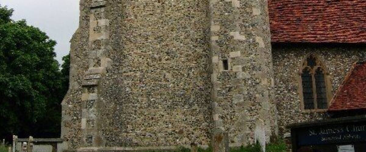 A historic stone church with a tall tower and a pointed spire.
