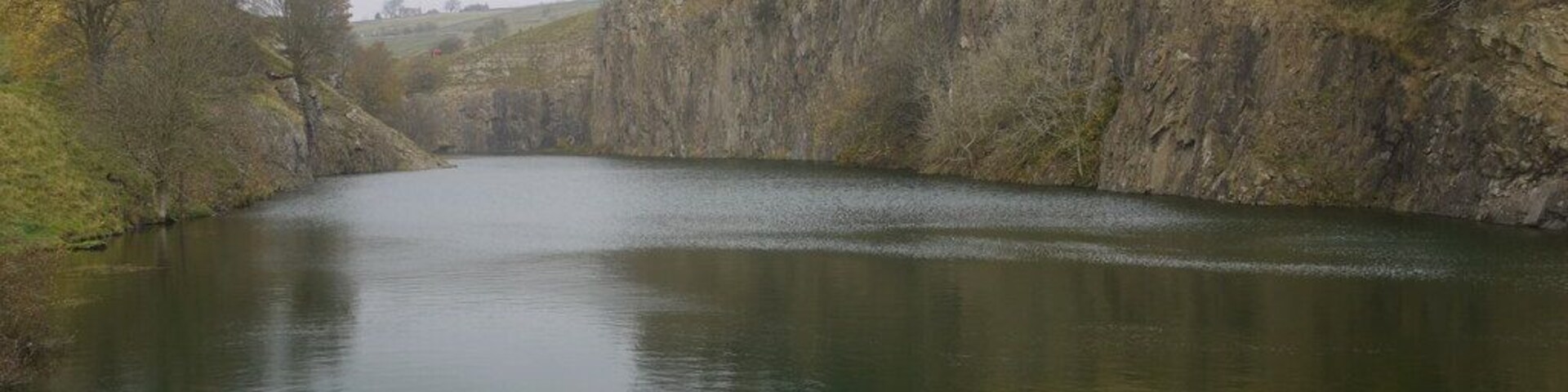 Copthill Quarry Disused and flooded quarry on the outcrop of the whin sill at Cowshill. The quarry was opened up in 1895 by Octavius Monkhouse who was the Innkeeper at the nearby Cowshill Inn and son of the local minister. The quarry is one of two whinstone quarries in Weardale, the other is at Stanhope, and rock was carted from the quarry to Wearhead railway station and from there down the dale for use in construction projects. About 50 men worked the quarry in the early days and as it developed permission was obtained to demolish first the vicarage and then the church itself. Now only the graveyard remains, above the quarry, north west of Copthill Farm. By 1926 the quarry was in financial difficulties and closed down but a group of local men formed the Cowshill Quarry Company and this new company took over and continued the work up until final closure in 1943. http://www.aditnow.co.uk/mines/Copt-Hill-Whinstone-Quarry/