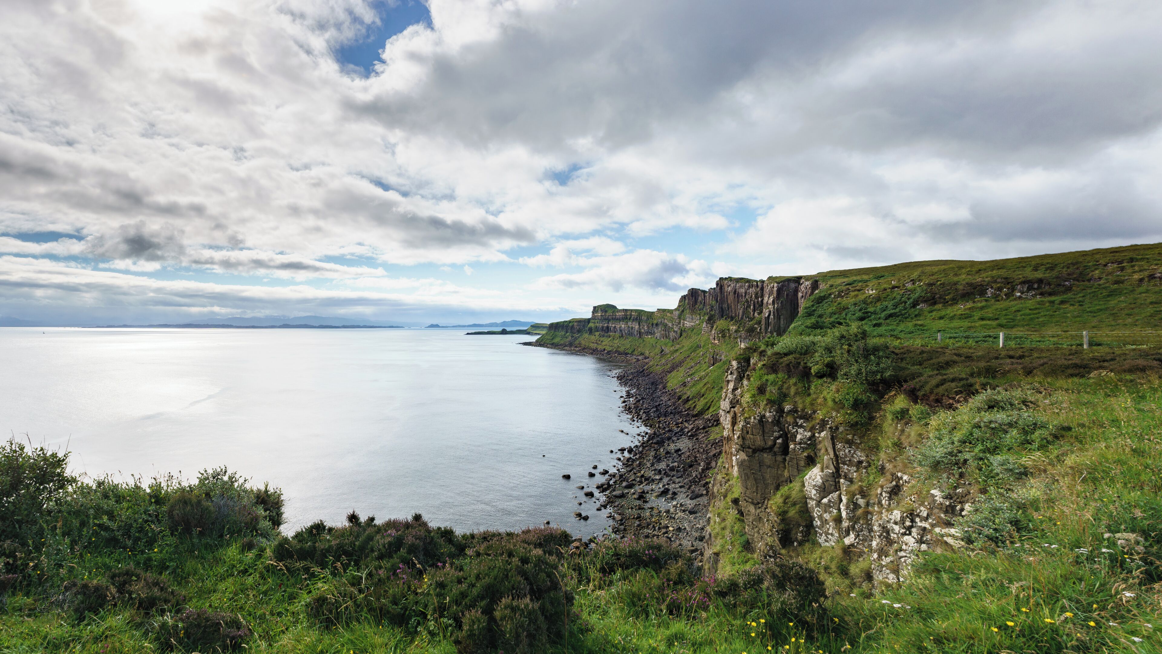 Looking southward at the Mealt Waterfall viewpoint near Ellishadder. The isles of Rona and Raasay are visible. Photographer's notes: The image is composed of several frames combined with Lightroom's Photo Merge Panorama function. The scene was exposed for the highlights.