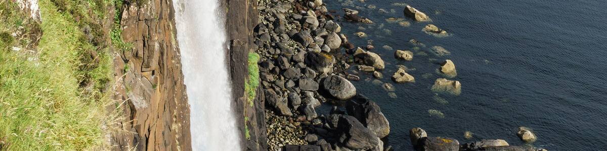 The waterfall from Loch Mealt falls 55 metres to the sea. Behind is Kilt Rock, 90 metres tall, so-called because the combination of basalt columns upon a sandstone base resembles a kilt.