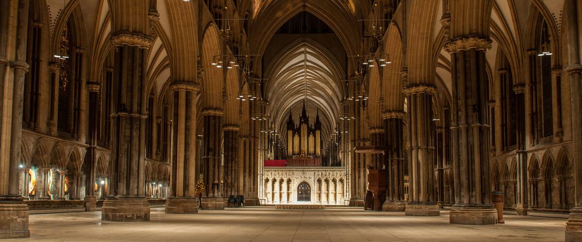 A cathedral interior with high vaulted ceilings and rows of columns.