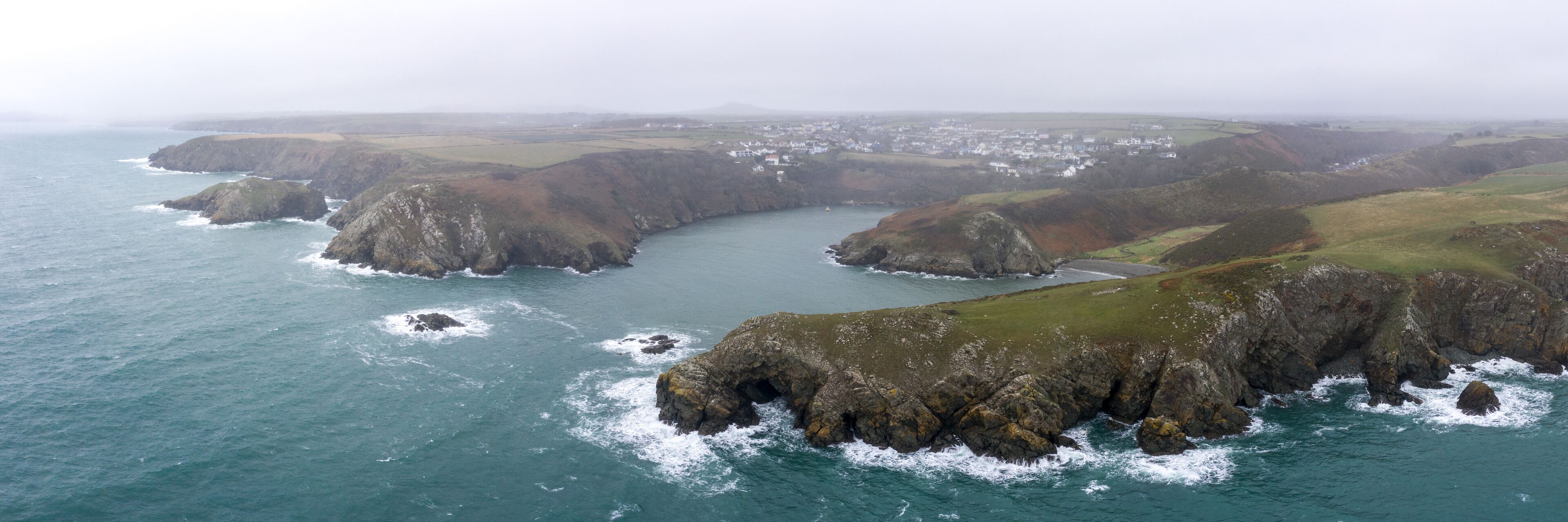 A rugged coastline with rocky cliffs and a small bay.