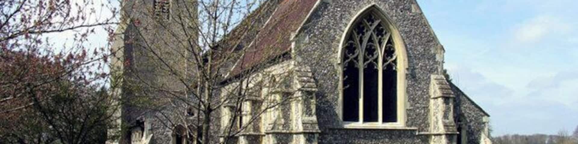 A church with a tall tower and a large arched window.
