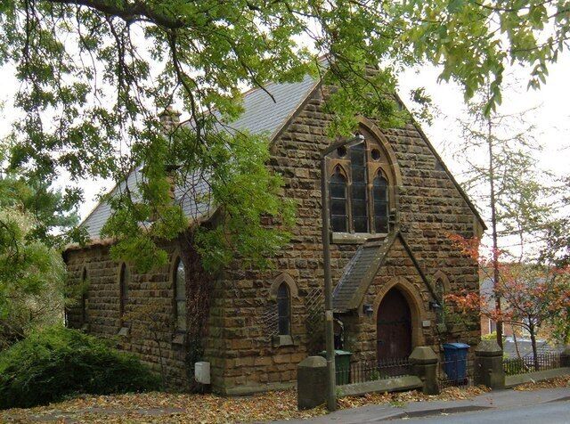 A stone church with a pointed arch and a bell tower.