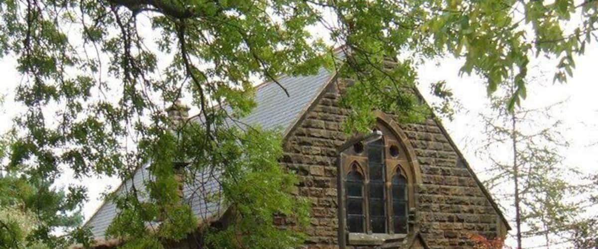 A stone church with a pointed arch and a bell tower.