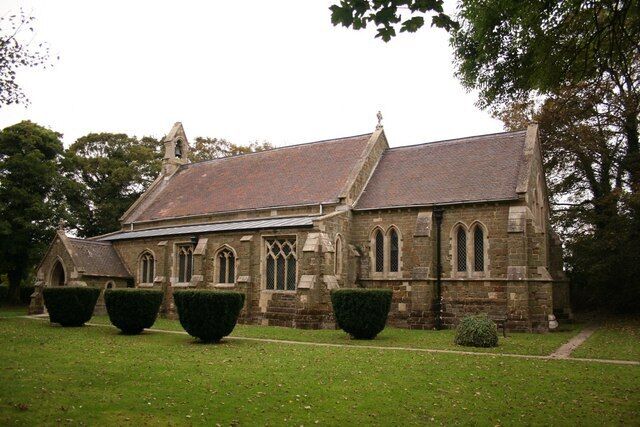 A historic church with a steep roof, arched windows, and a stone facade.