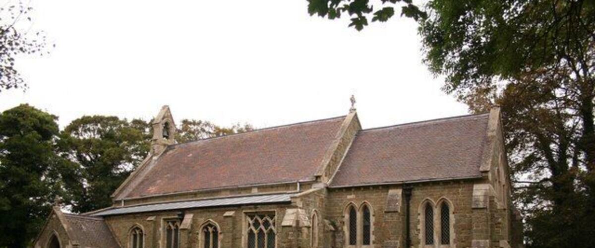 A historic church with a steep roof, arched windows, and a stone facade.