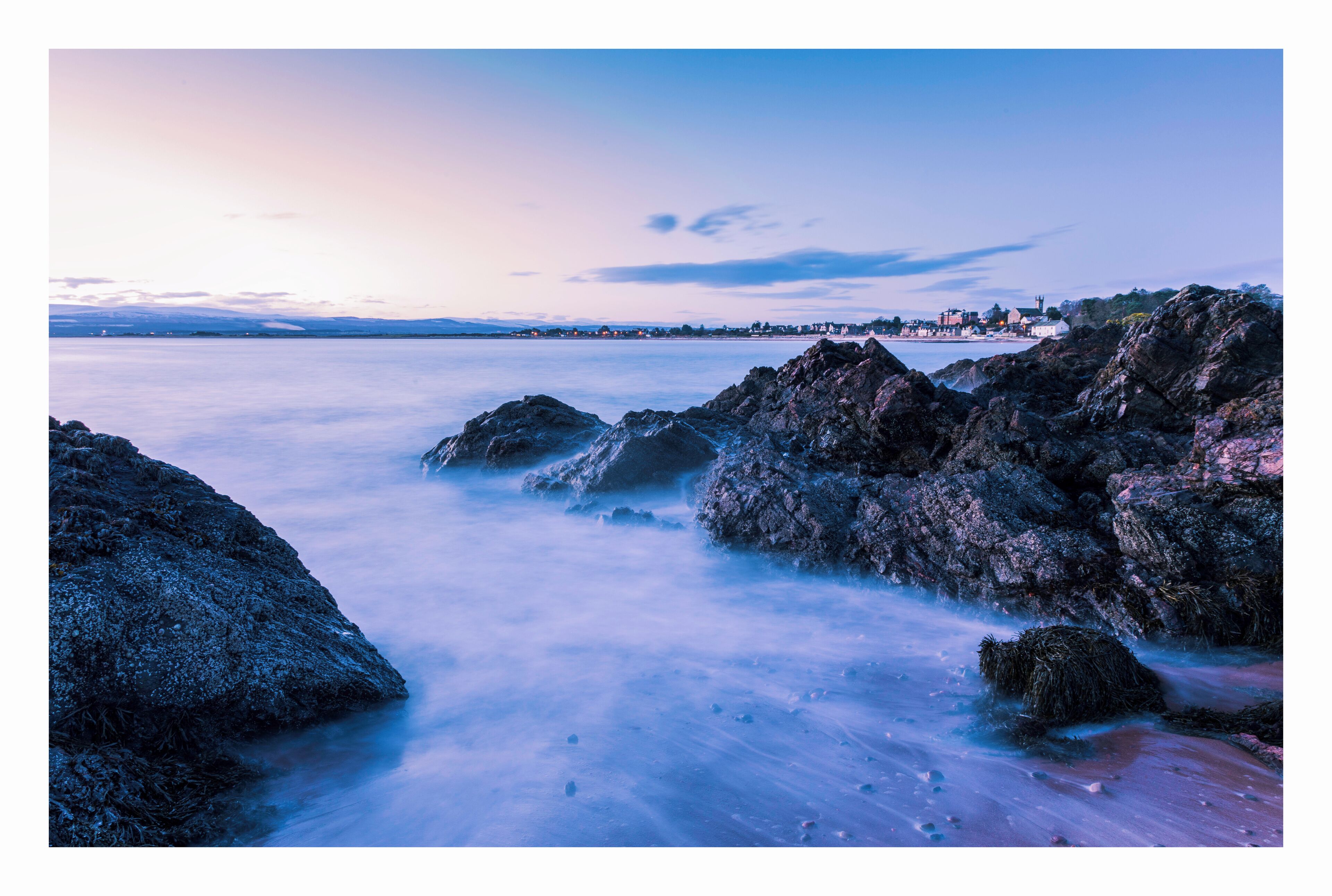 A coastal landscape with rocky shores and calm water.