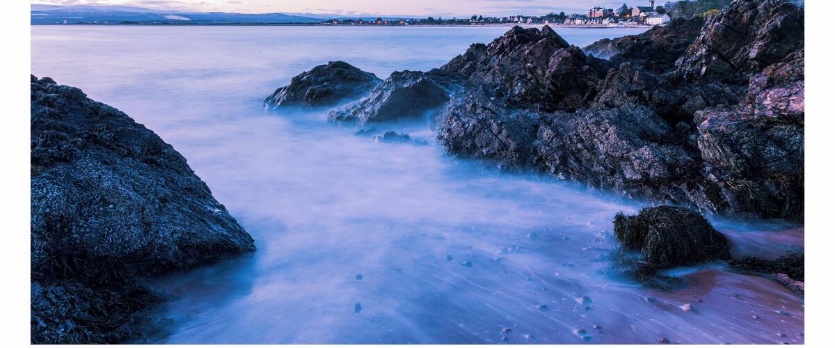 A coastal landscape with rocky shores and calm water.