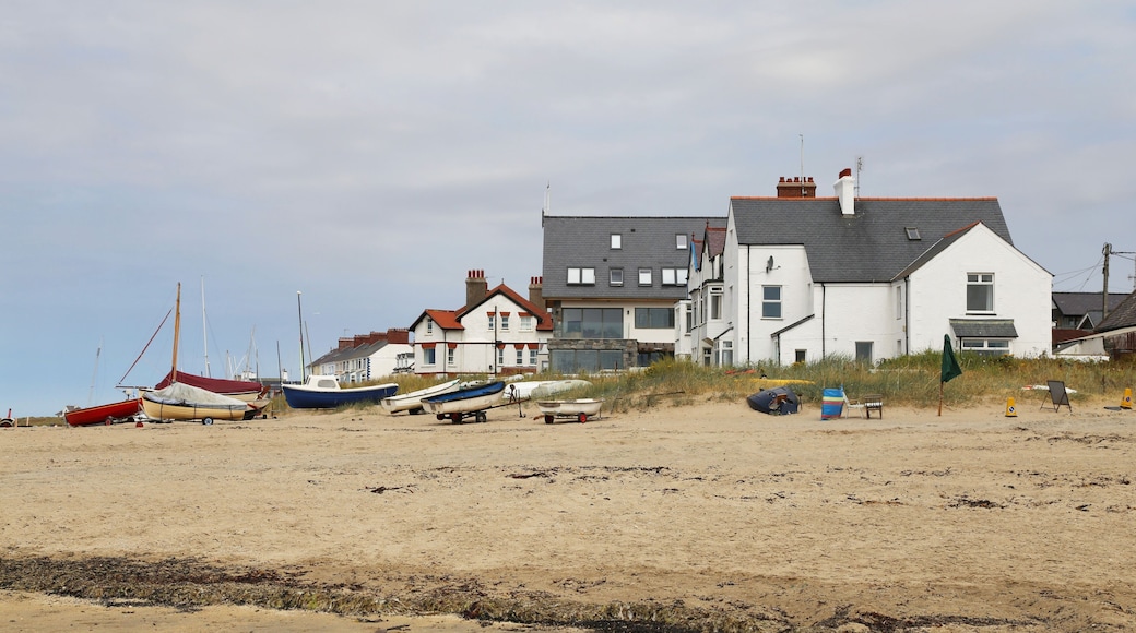 British beach side houses and boats on the sand at Rhosneigr, Isle of Anglesey, Wales, UK.