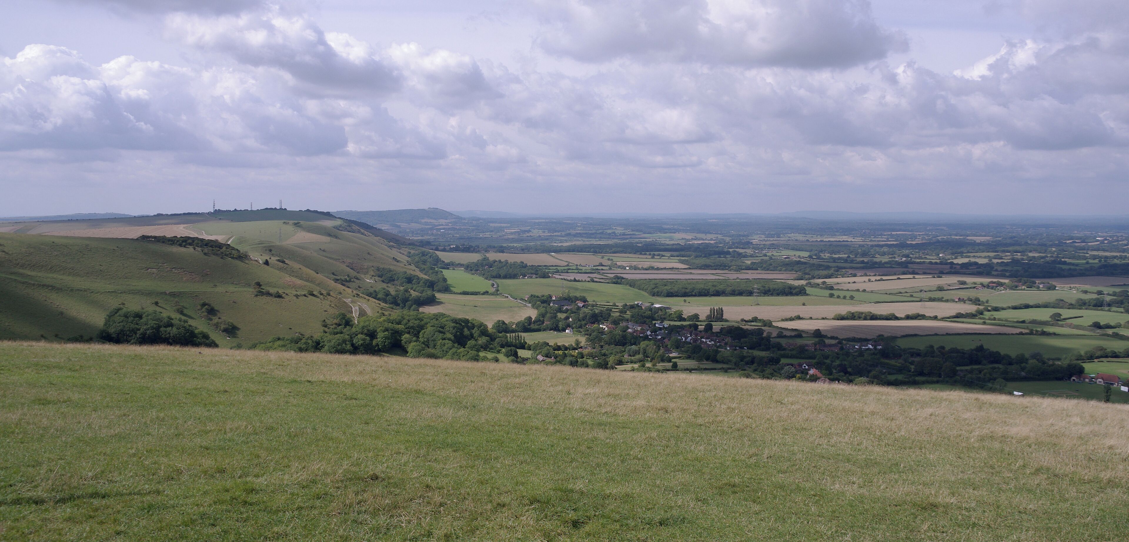 Rolling hills, a small village, and a distant hilltop.