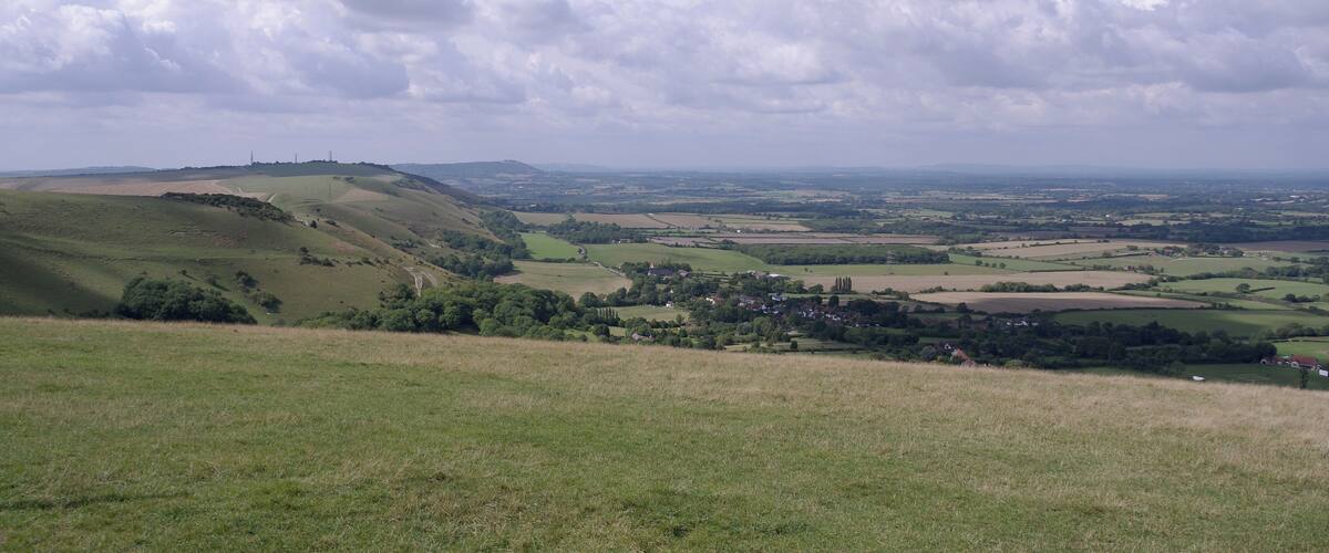 Rolling hills, a small village, and a distant hilltop.