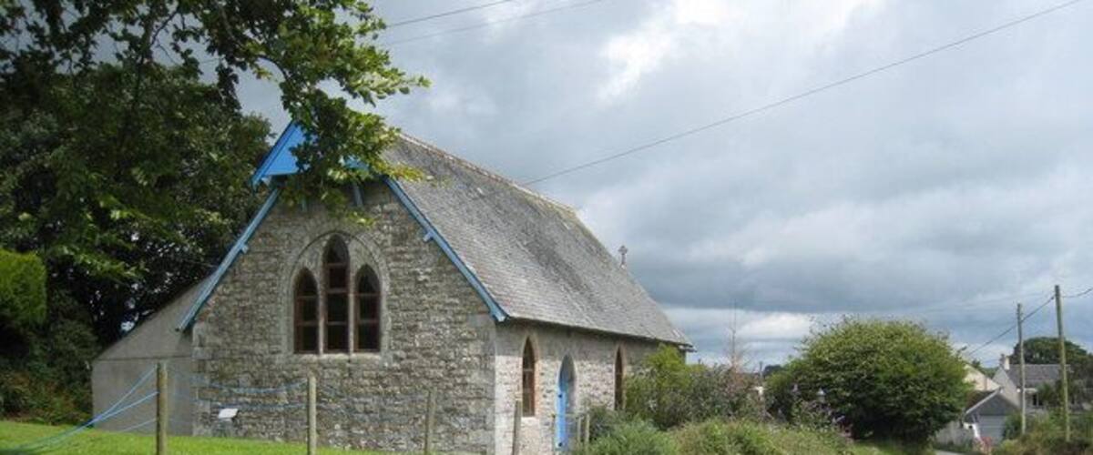 A stone church with a blue roof and arched windows.