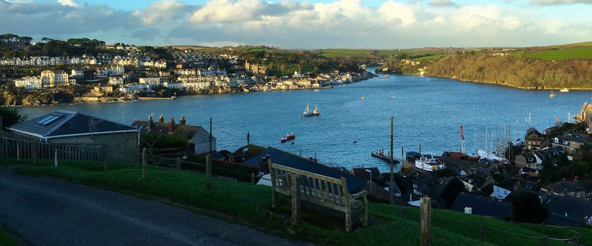 A coastal town with a harbor, boats, and houses along the waterfront.
