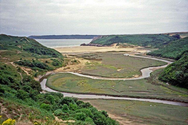 The meandering Pennard Pill. View of the Pennard Pill as it meanders towards the sea in Three Cliffs Bay, taken from near the ruined chapel and castle.
