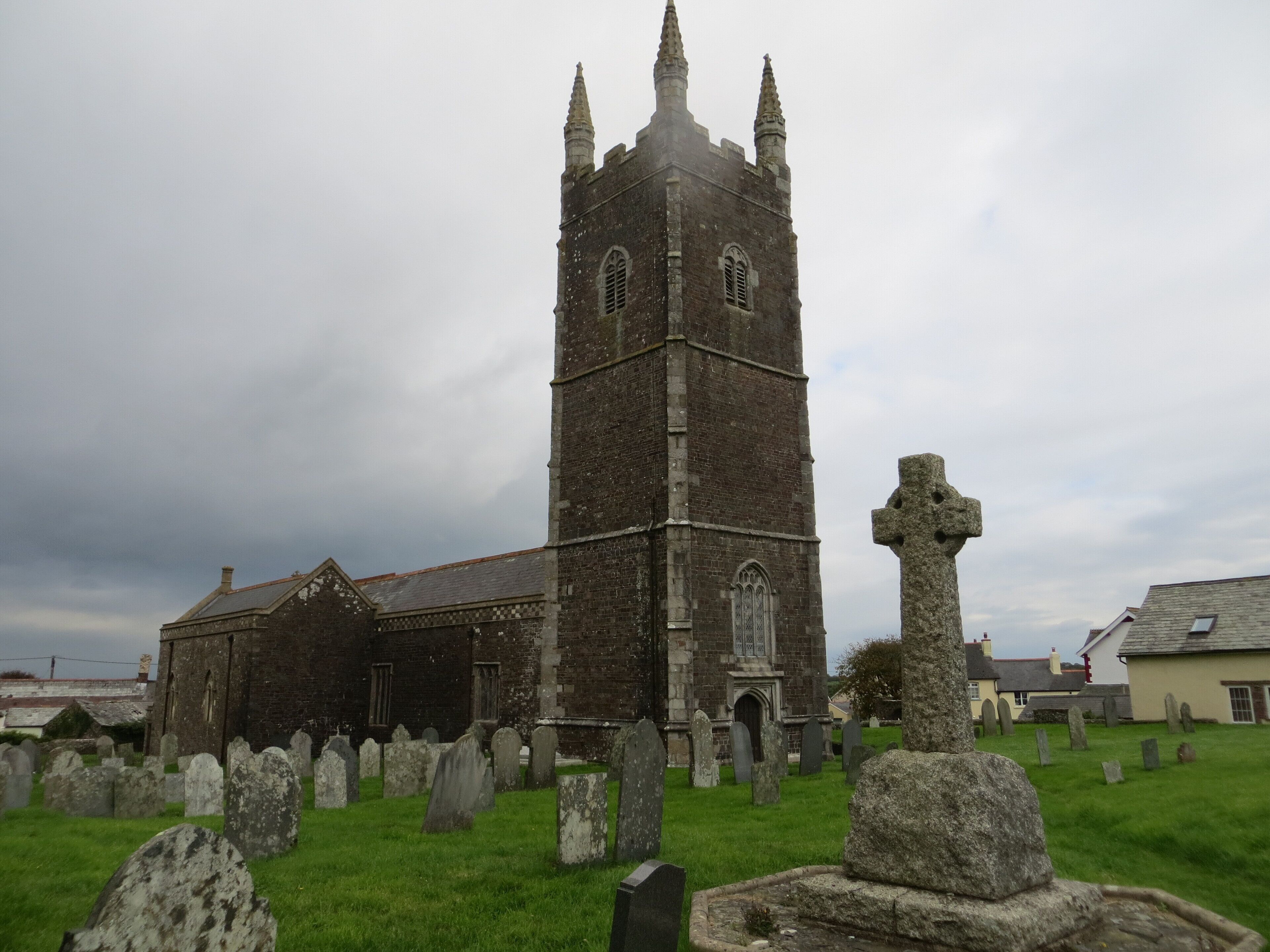 A church with a tall tower and a graveyard with headstones.