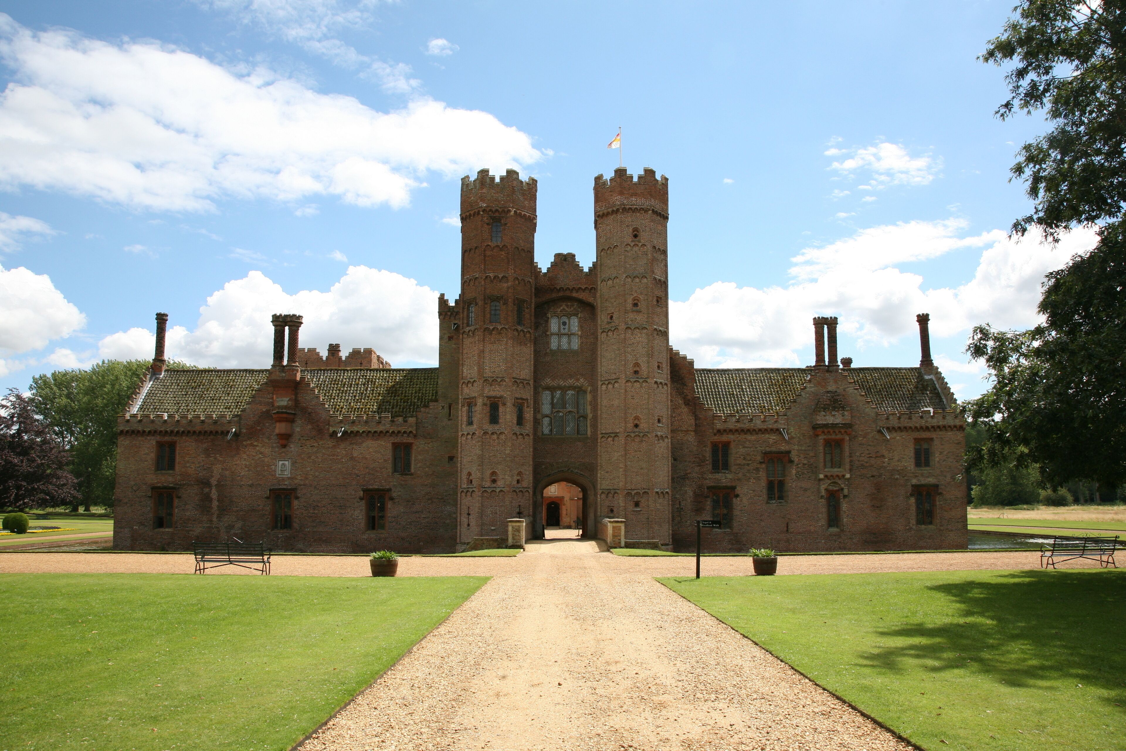 A large brick castle with two towers and a central entrance.