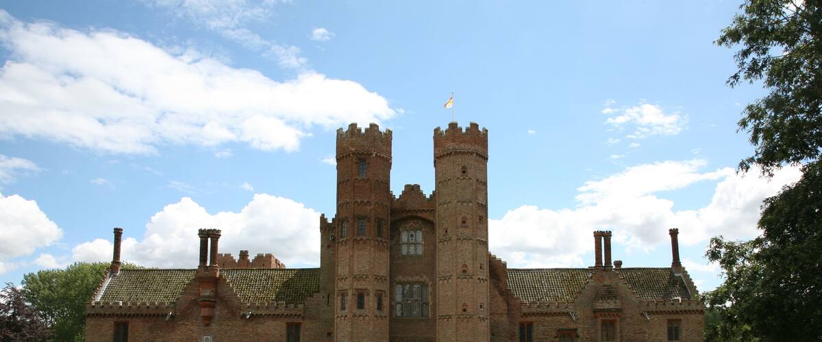 A large brick castle with two towers and a central entrance.