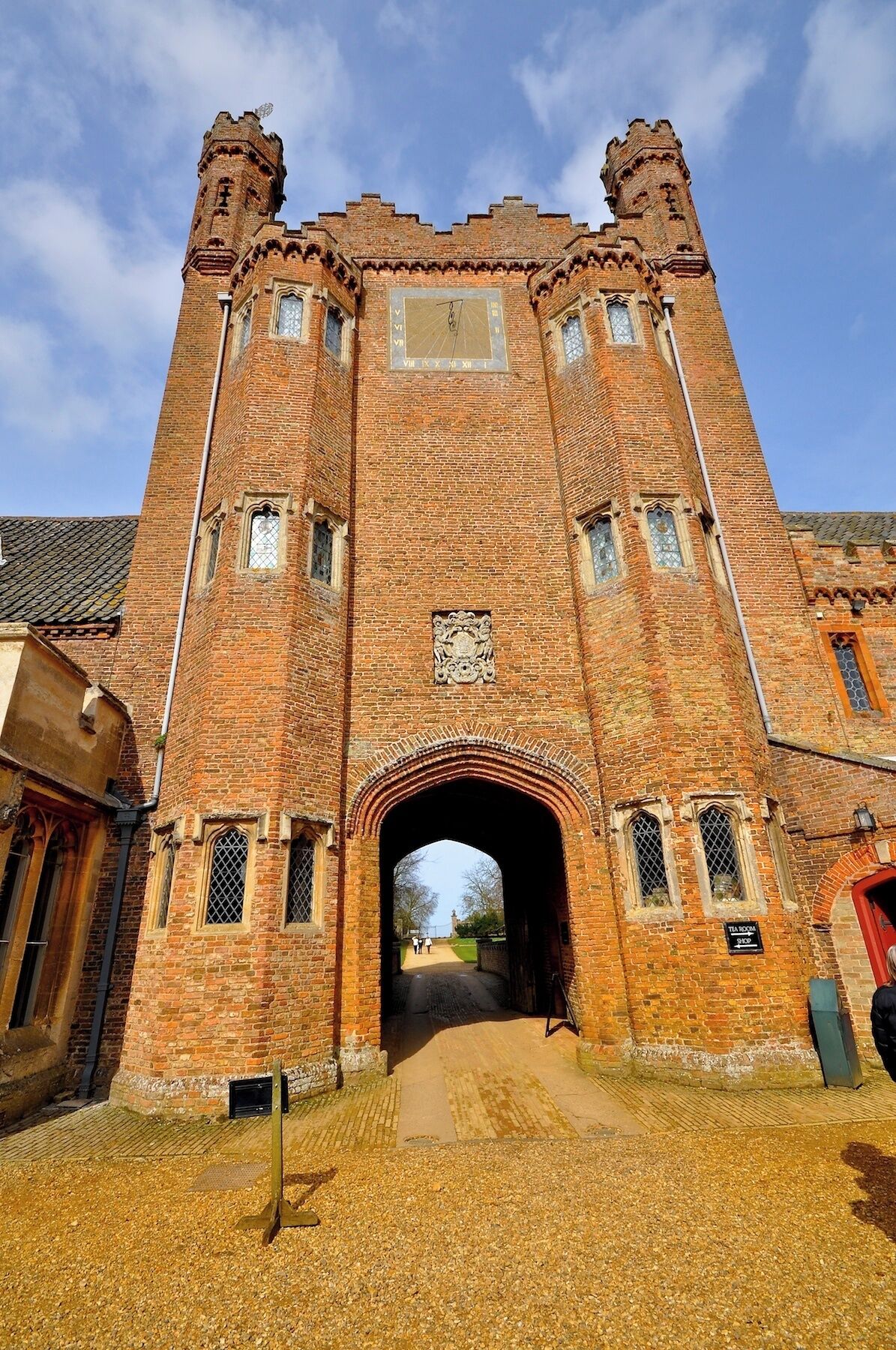 A large brick building with a central archway and two towers.