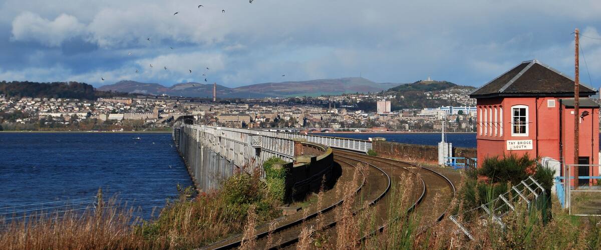 A coastal town with a bridge over water, railway tracks, and a red building labeled 'TAY BRIDGE SOUTH'.