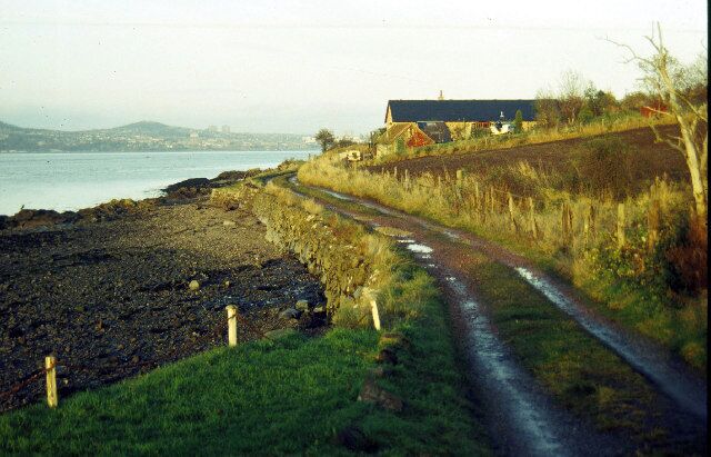 Balmerino. The village street in Balmerino peters out into this track which leads to a few cottages on the shore of the Firth of Tay. Dundee can be seen in the distance on the opposite bank .